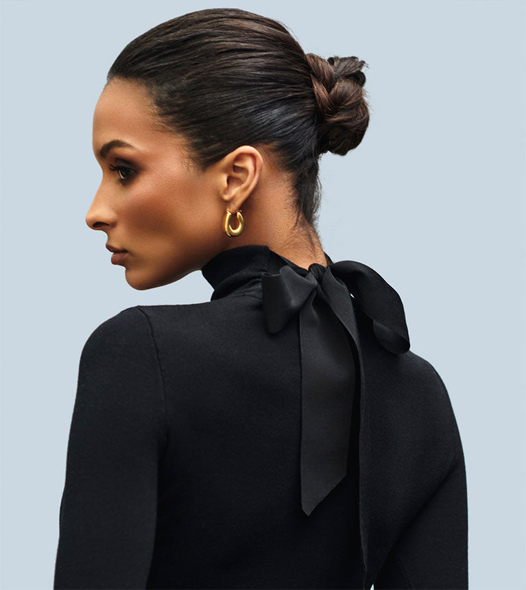 woman wearing black long sleeve turtleneck top with bow in the back